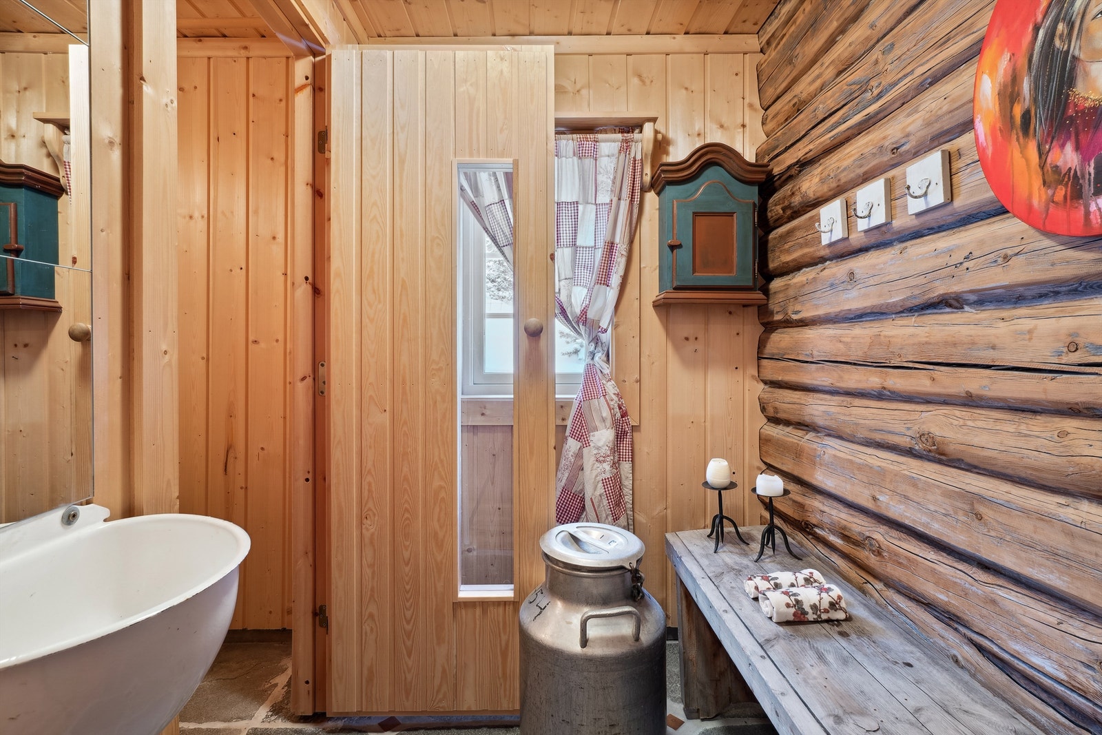 I gangen foran badstuen er det grå skifer på gulvet og panel og laft på veggene. Her er det også en utslagsvask for gråvann på veggen. og sluk i gulvet. Galleribilde