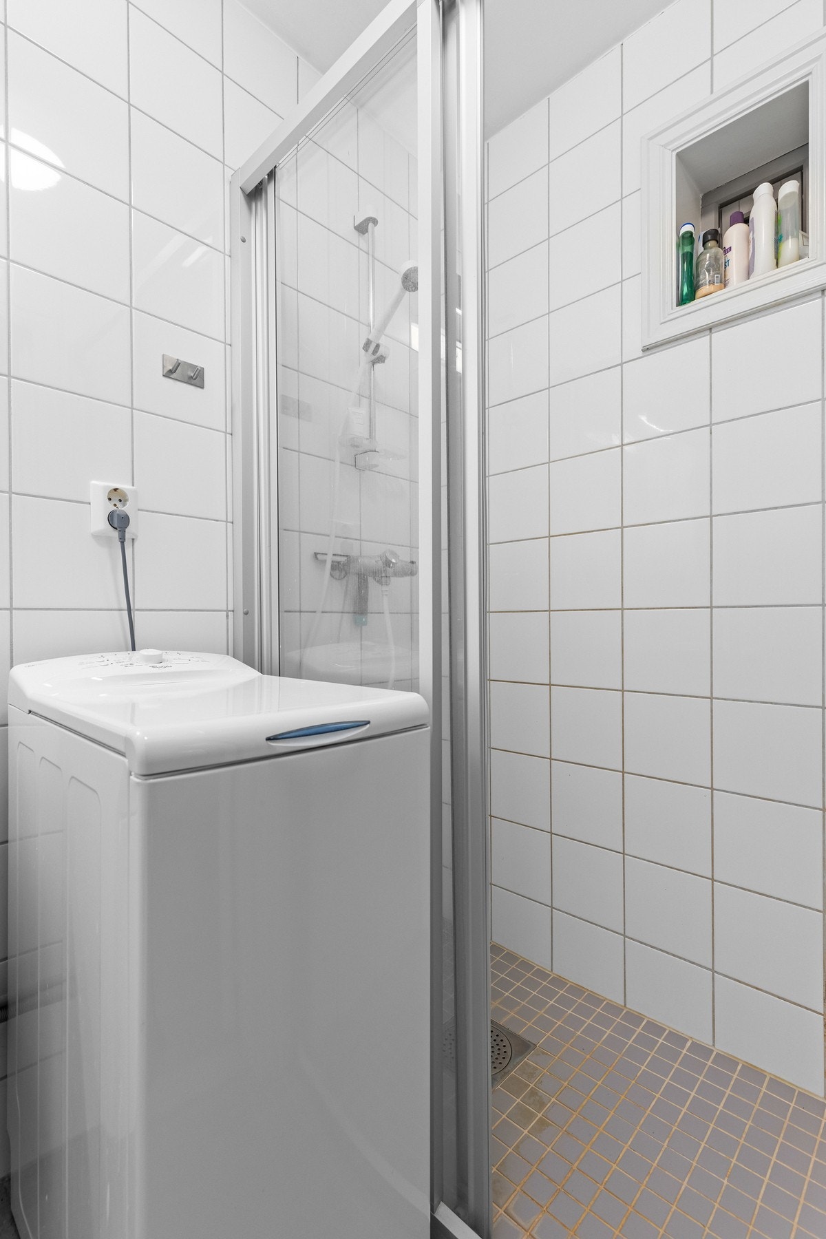 Badet har en dusjnisje med skyvedør og dusjgarnityr montert på veggen. Galleribilde