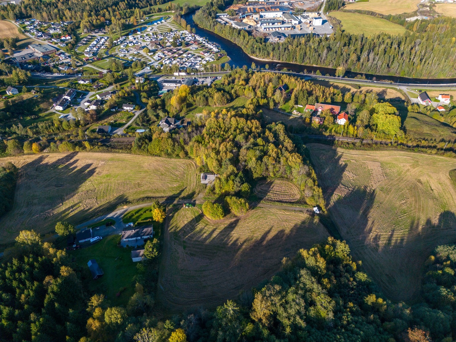Dronefoto av eiendommen og området rundt. Sett fra vest. Bø elva i øvre kant av bildet. Galleribilde