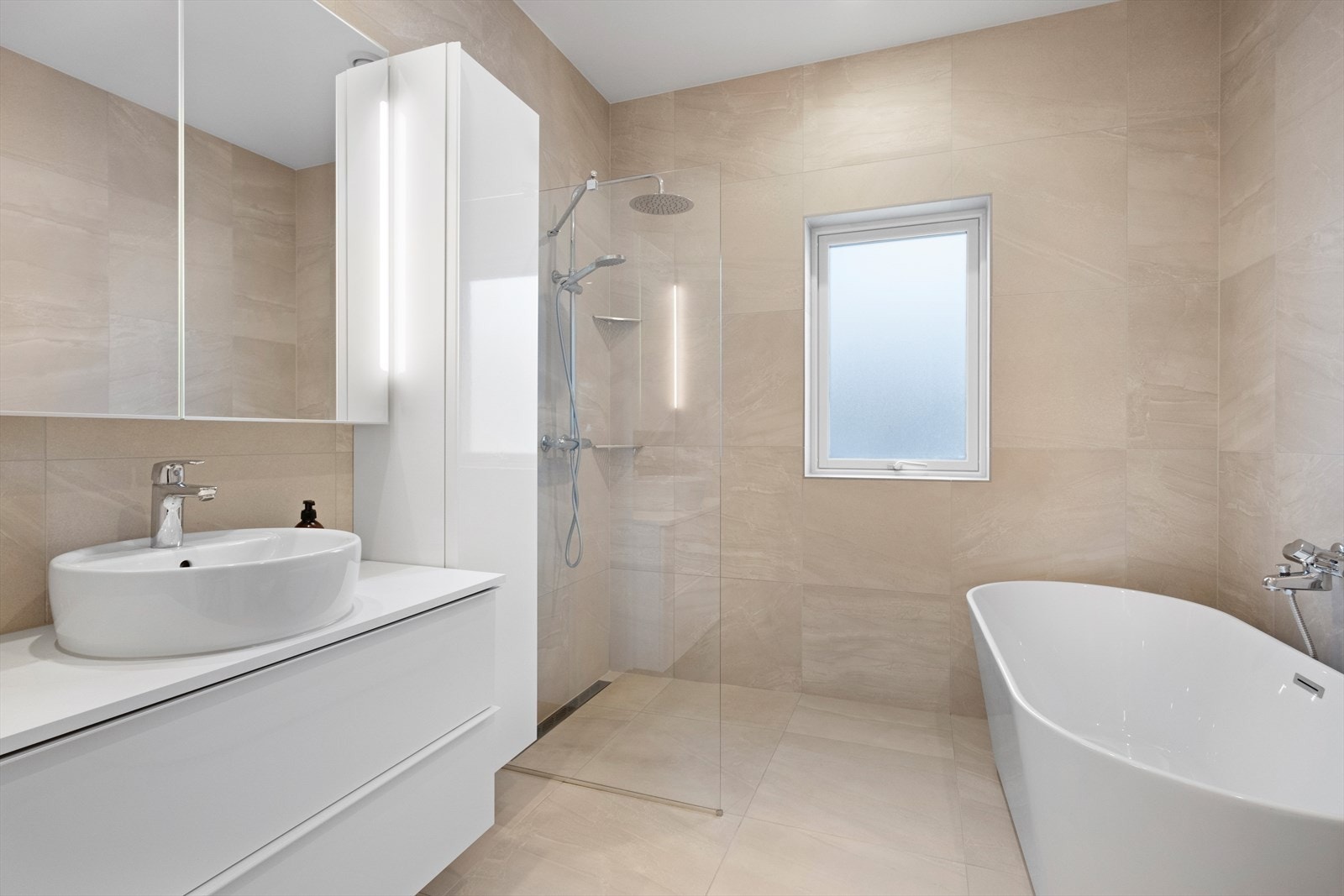 I 2. etasje er det et lekkert bad med fliser og varmekabler på gulv og flis på vegger. Dusjhjørne med glassvegg, badekar, veggmontert toalett og servantskål med underskap. Ventilasjon i himling. Galleribilde