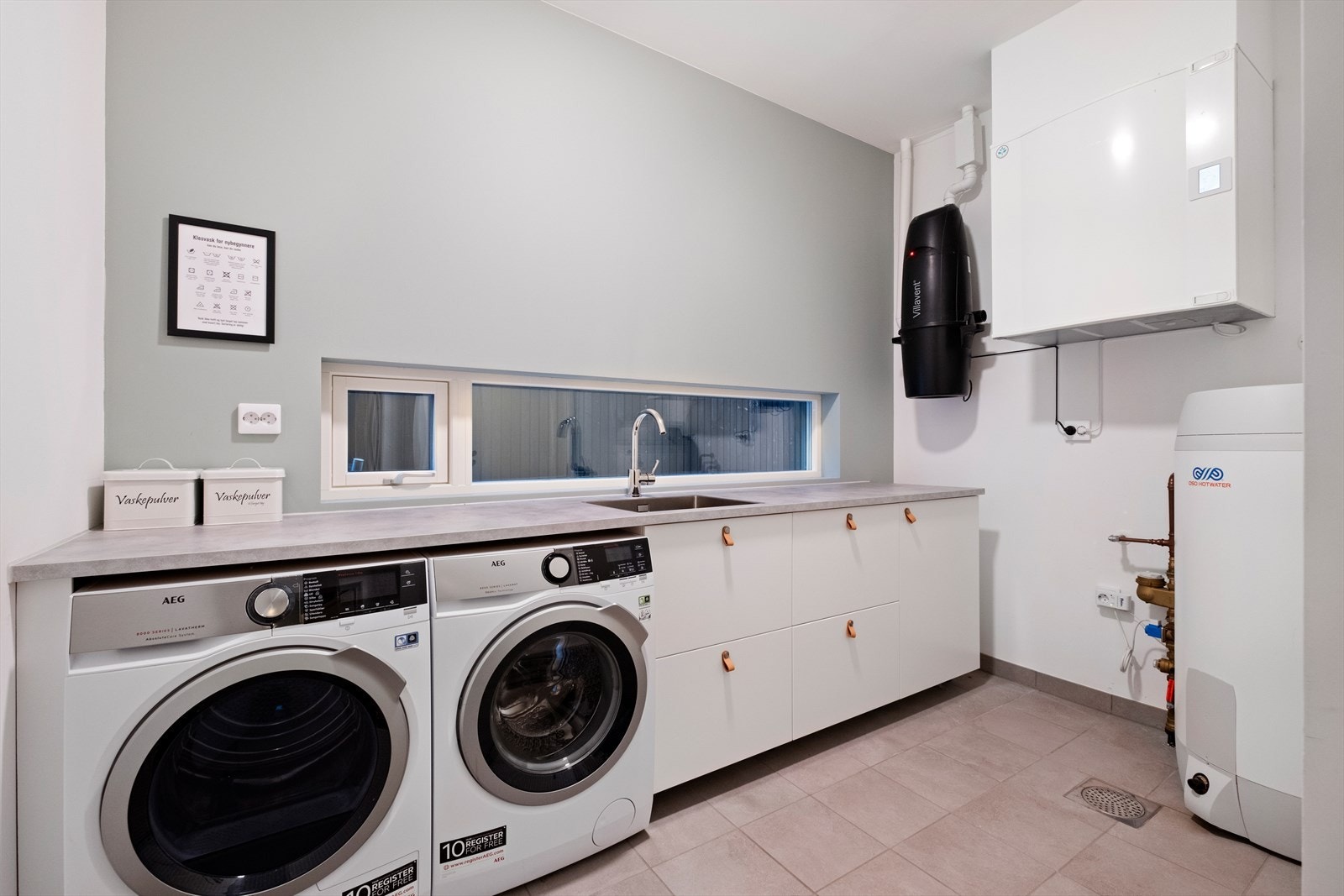 Praktisk vaskerom med mye lagringsplass og benkeplass. Galleribilde
