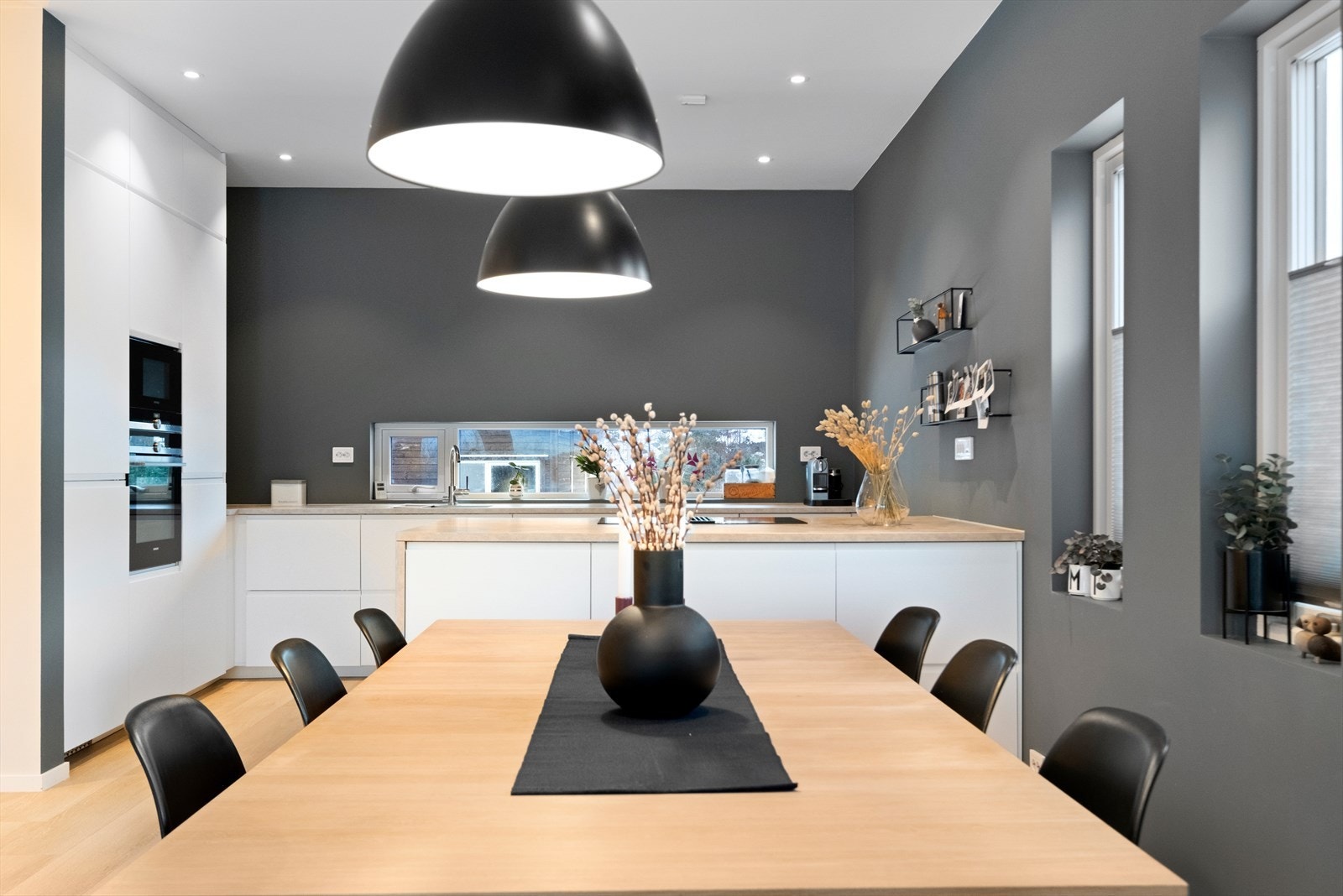 Praktisk kjøkkeninnredning fra Ikea med slette fronter. Det er integrert ventilator i koketopp, integrert stekeovn, mikrobølgeovn, oppvaskmaskin, kjøleskap, fryseskap og vinskap. Laminat benkeplate med nedfelt oppvaskkum. Galleribilde