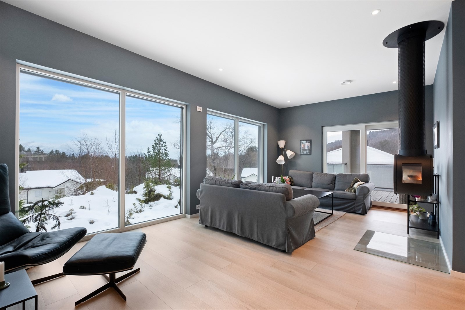 Stue med store vindusflater mot syd. Lekker og moderne fritthengende vedovn. Galleribilde
