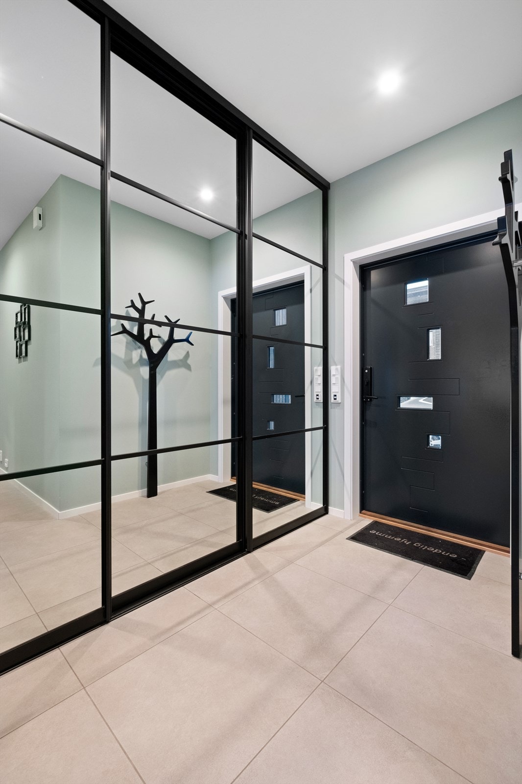 Velkommen inn. Her er en romslig gang med skyvedørsgarderobe Galleribilde