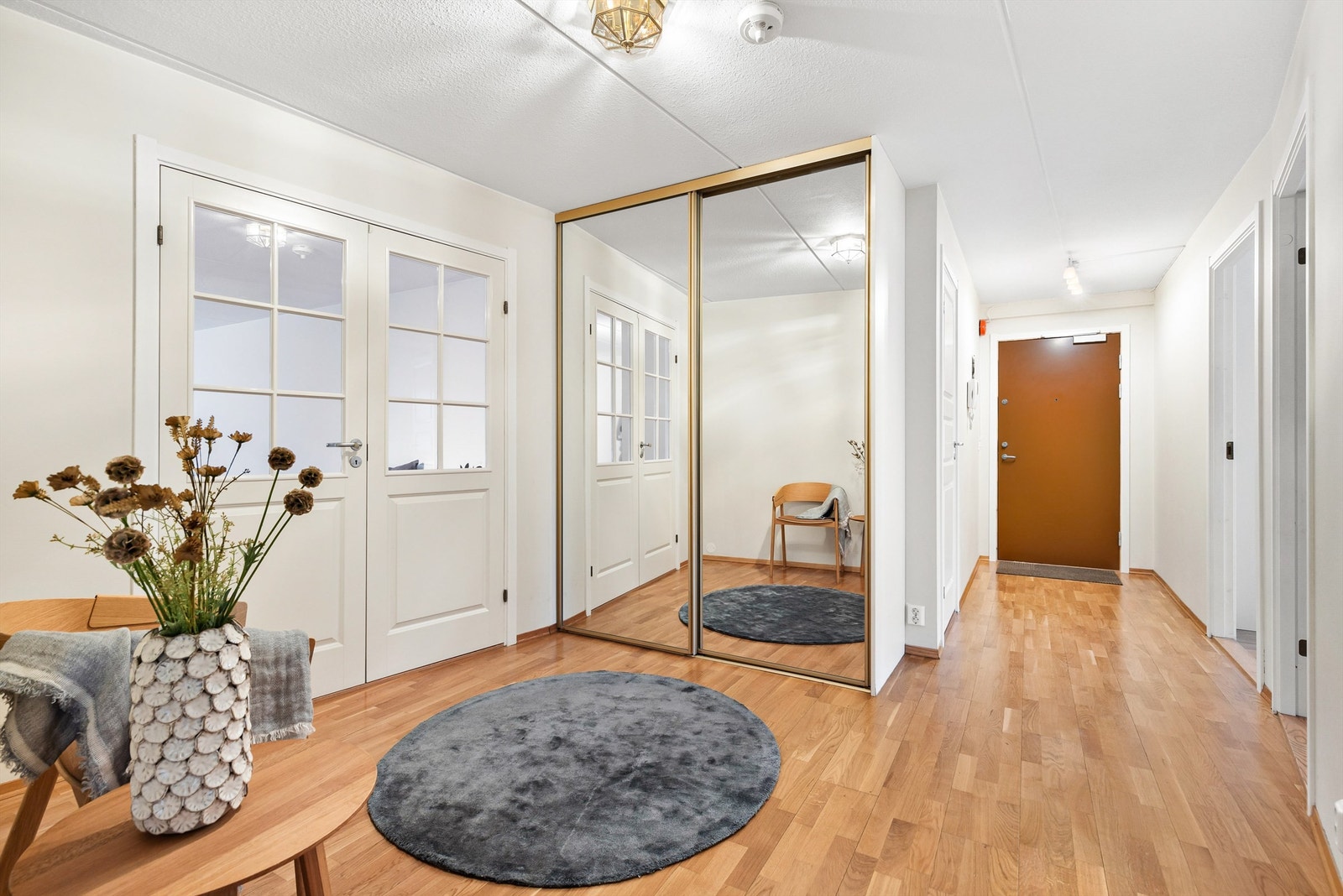 Her er det integrert garderobeskap fra gulv til tak med speilfronter. I tillegg er det god plass til en benk og kommode. Galleribilde