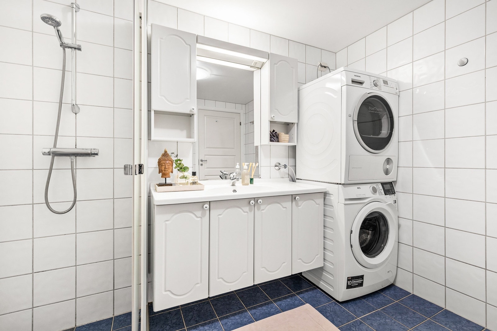 Vegghengt servantskap med ett-greps armatur. Vegghengt speilskap med overbelysning og stikkontakt. Galleribilde