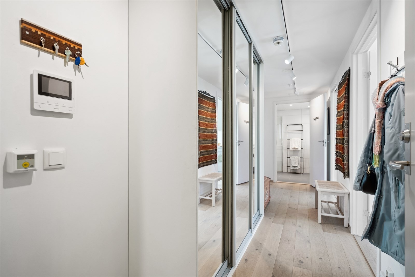 Innbydende entre med god plass til oppbevaring i skyvedørsgarderobe med speilflater. Galleribilde