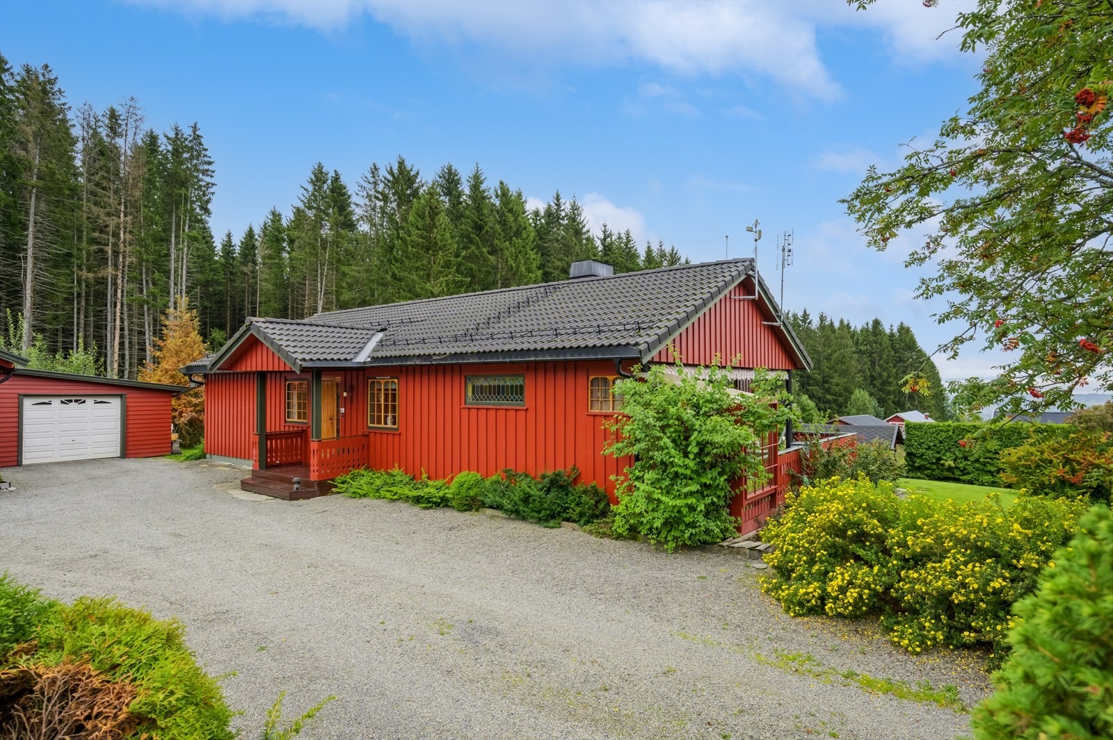 Eiendommen har gruslagt gårdsplass frem til inngangsparti og uthus på ca. 70 kvm med to garasjer og ett snekkerverksted. Galleribilde