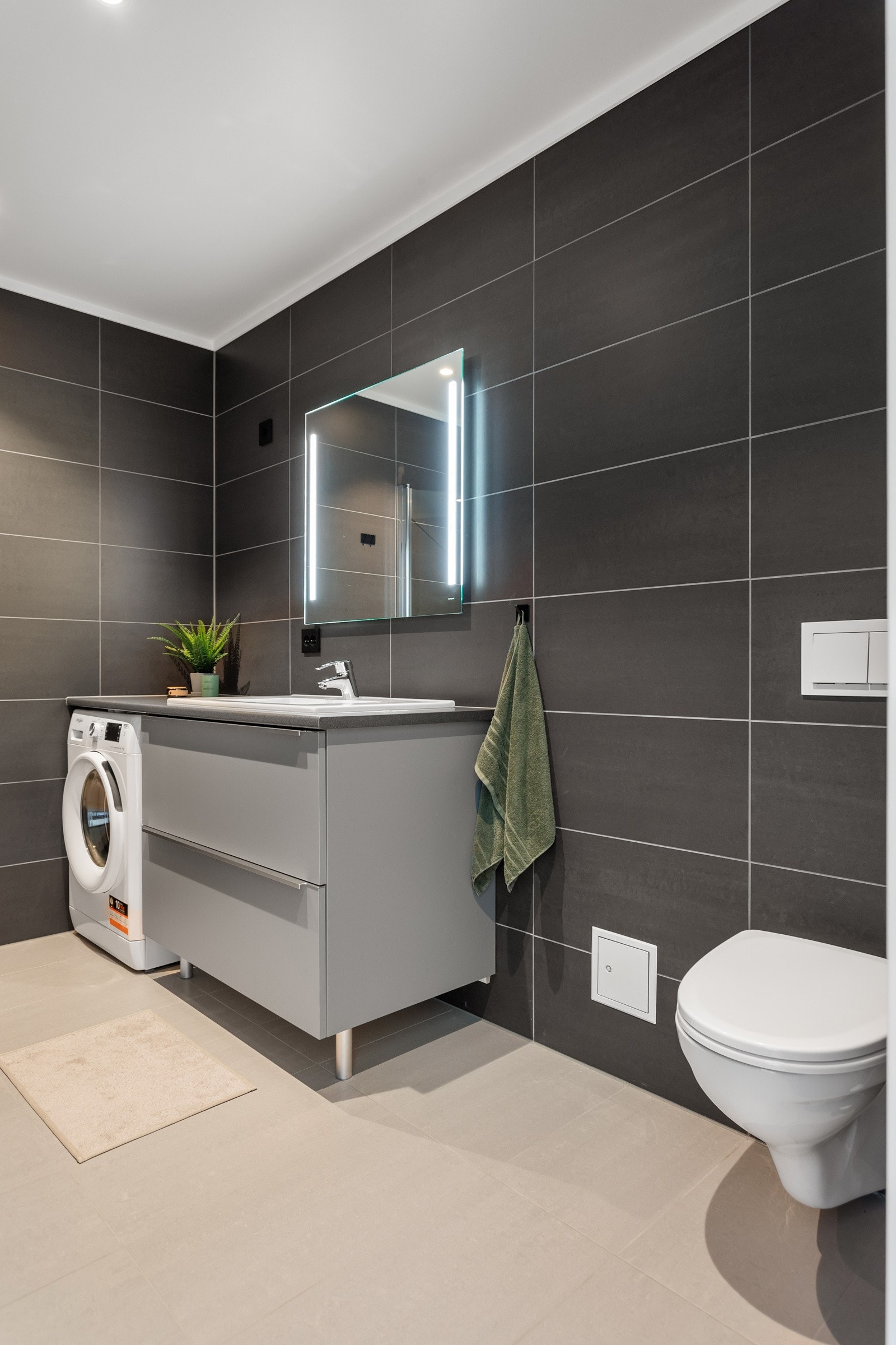 Badet utstyrt med opplegg for vaskemaskin og tørketrommel samt stikkontakt på vegg. Galleribilde