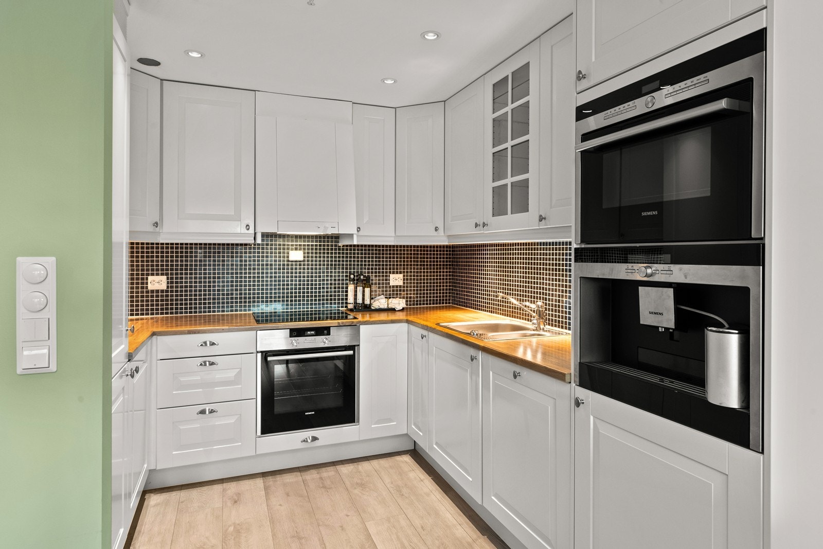 Lettstelt og godt utnyttet kjøkkensone med integrerte hvitevarer bestående av komfyr, platetopp,
kaffemaskin, oppvaskmaskin og kjøl /frys Galleribilde