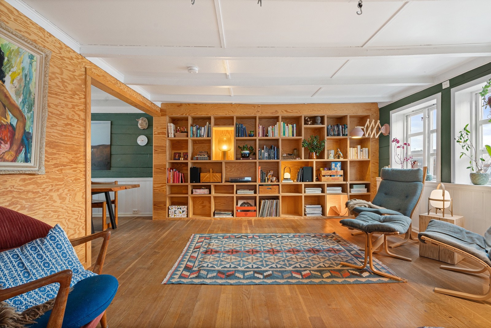 En stedbygd bokhylle i kryssfiner er et imponerende innslag som gir karakter til rommet. Galleribilde