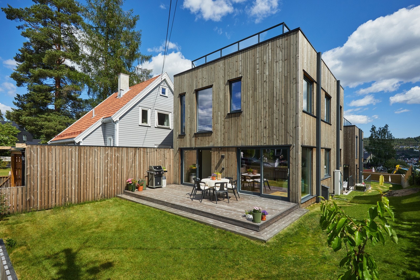 Tilnærmet vedlikeholdsfritt hushold i form av kledning og gjerde i jernvitrolbehandlet malmfuru fra Hasås og markterrasse i Kebony. Galleribilde