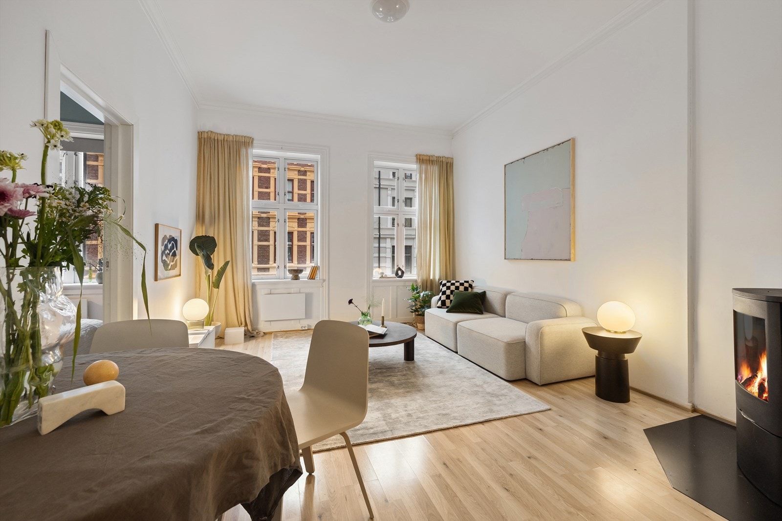 Stuen i leiligheten er romslig og flott opplyst med store vindusflater som gir rikelig med naturlig lys Galleribilde