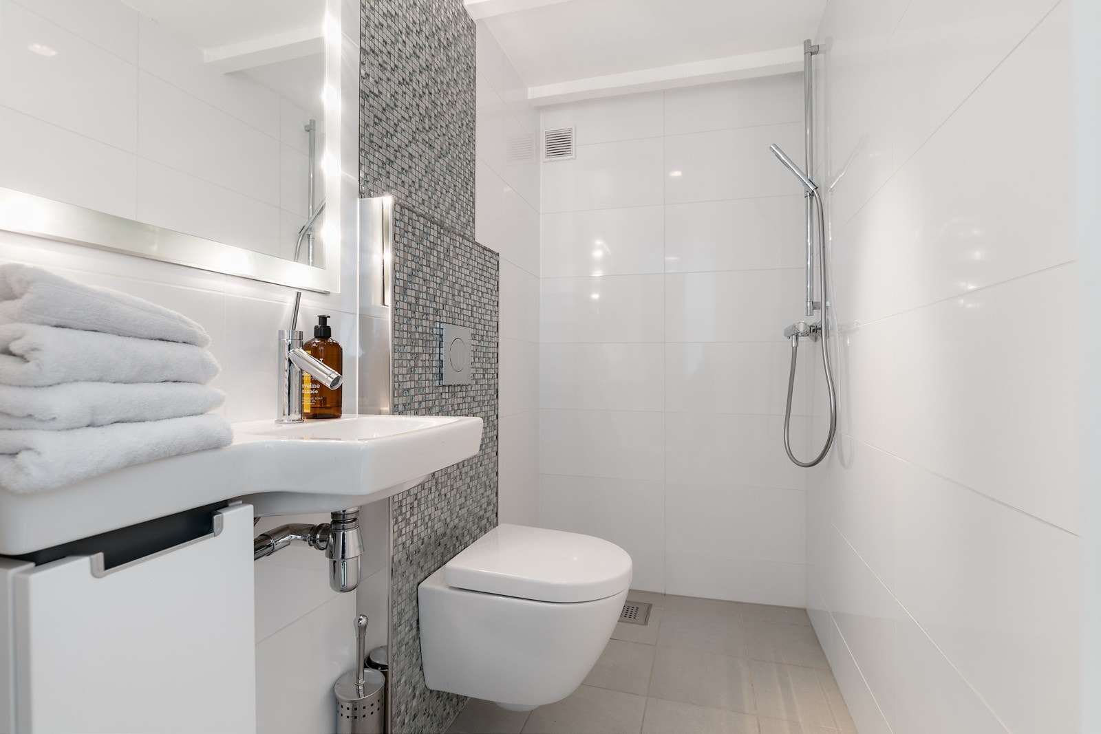 Lyst og pent bad i kjelleren med hvite fliser på veggene og sandfargede fliser på gulvet Galleribilde