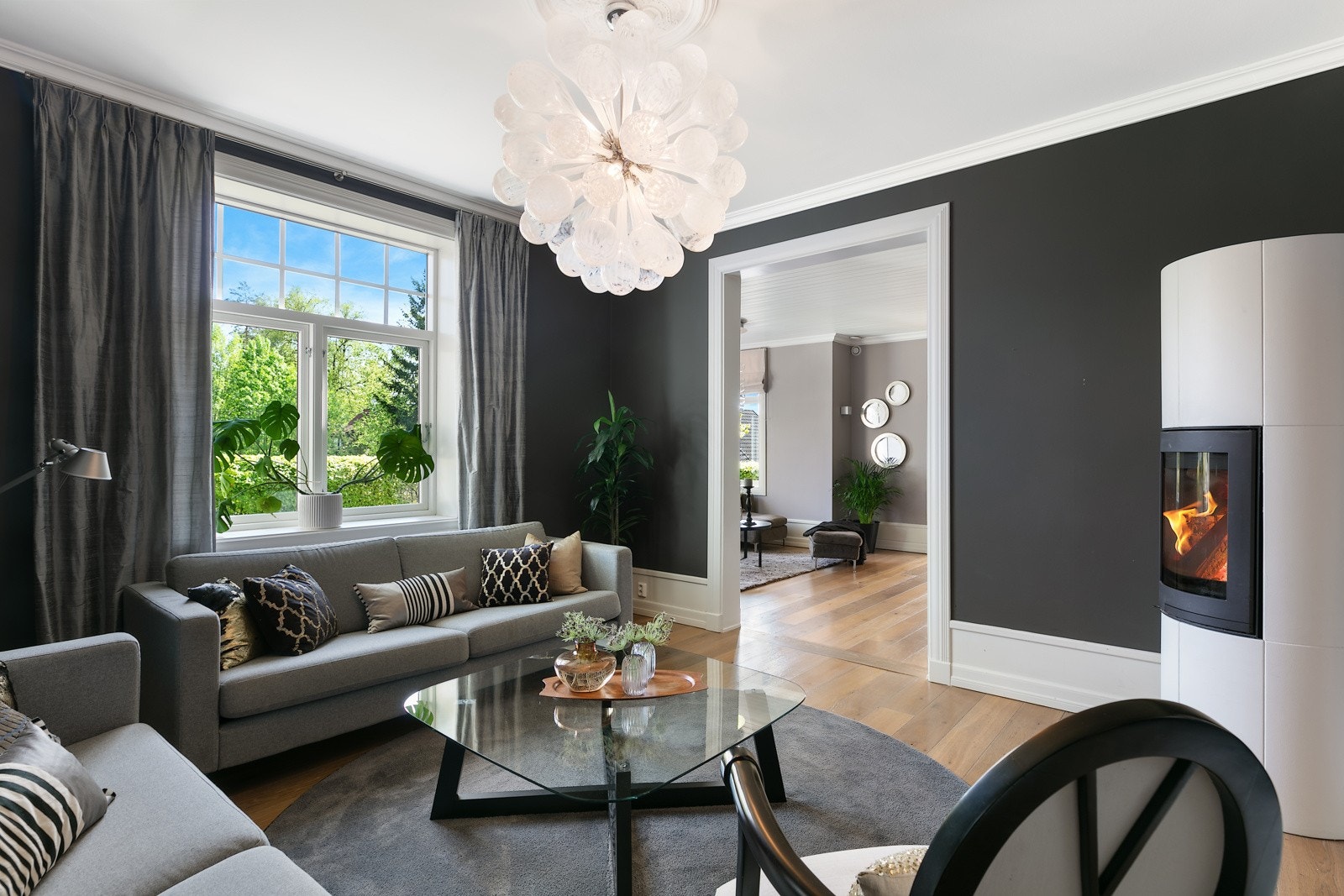 Stor hvit peis med sort innsats gir rommet en hyggelig stemning og ekstra god varme på kalde vinterdager Galleribilde