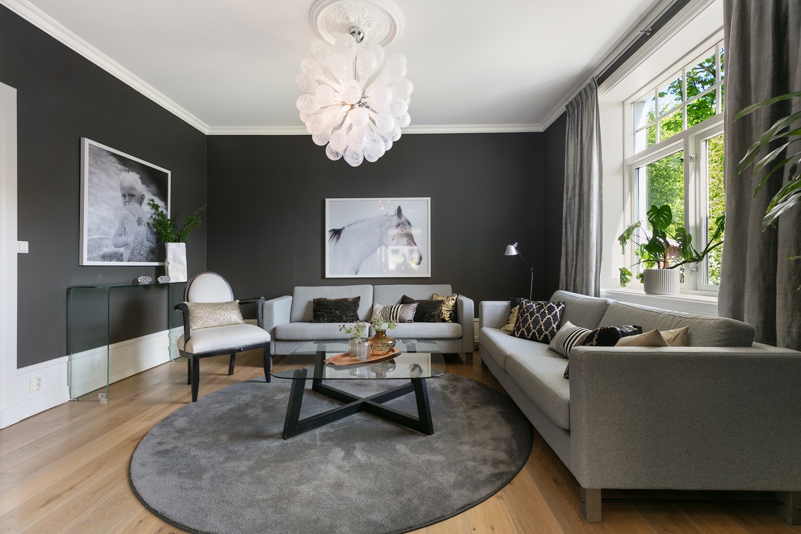 Stuen har plass til en sofagruppe og rommet fremstår lyst og hyggelig med stort vindu ut mot hagen Galleribilde