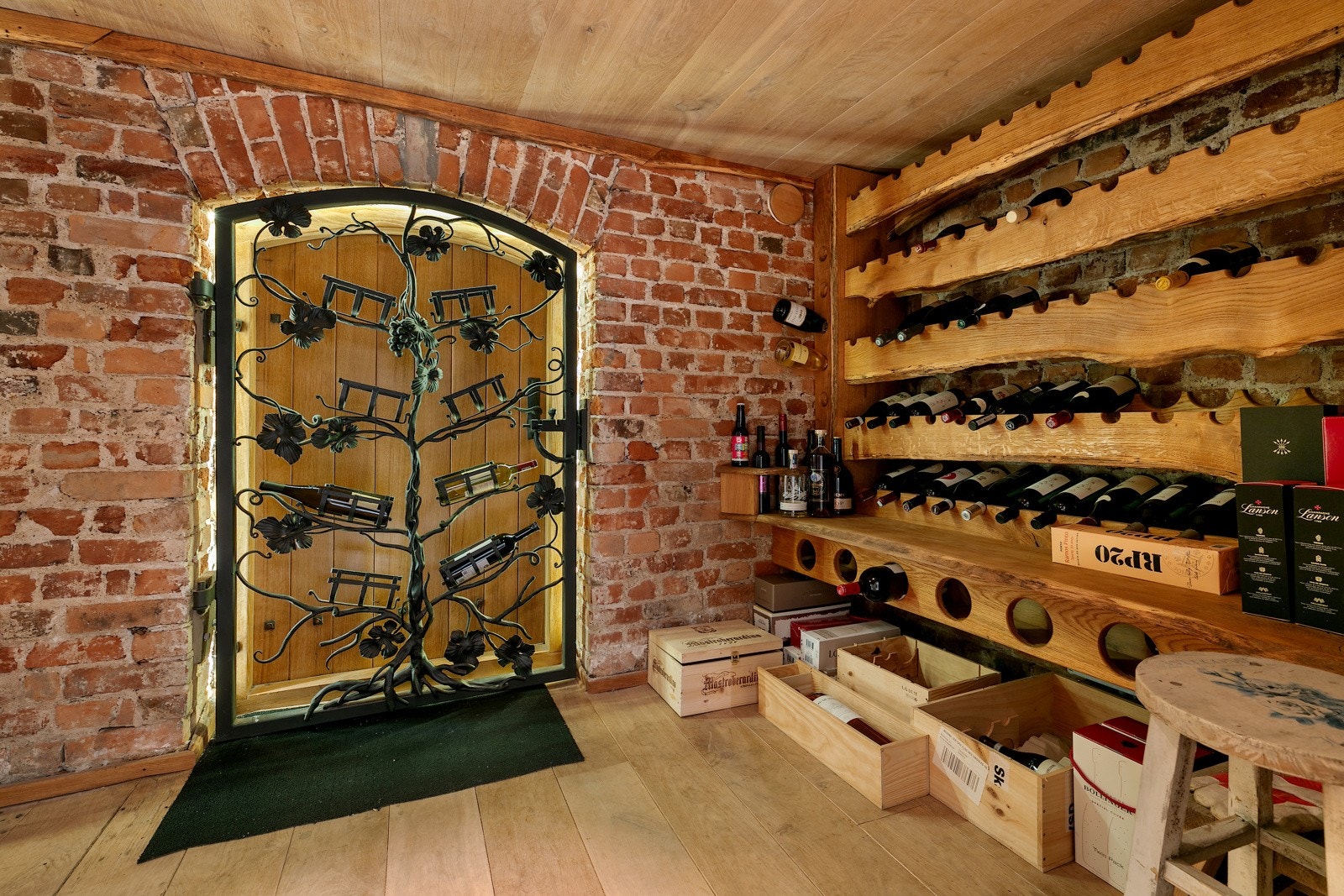 Rommet er innredet med vinhyller og en dekorativ smijerns dør ut mot hagen Galleribilde