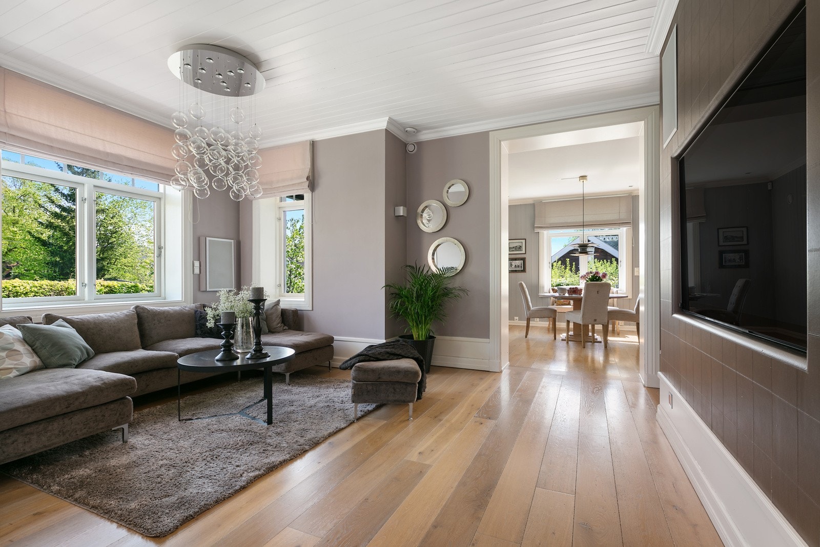 Stuen har store fine vinduer ut mot hagen som gjør rommet lyst og hyggelig Galleribilde