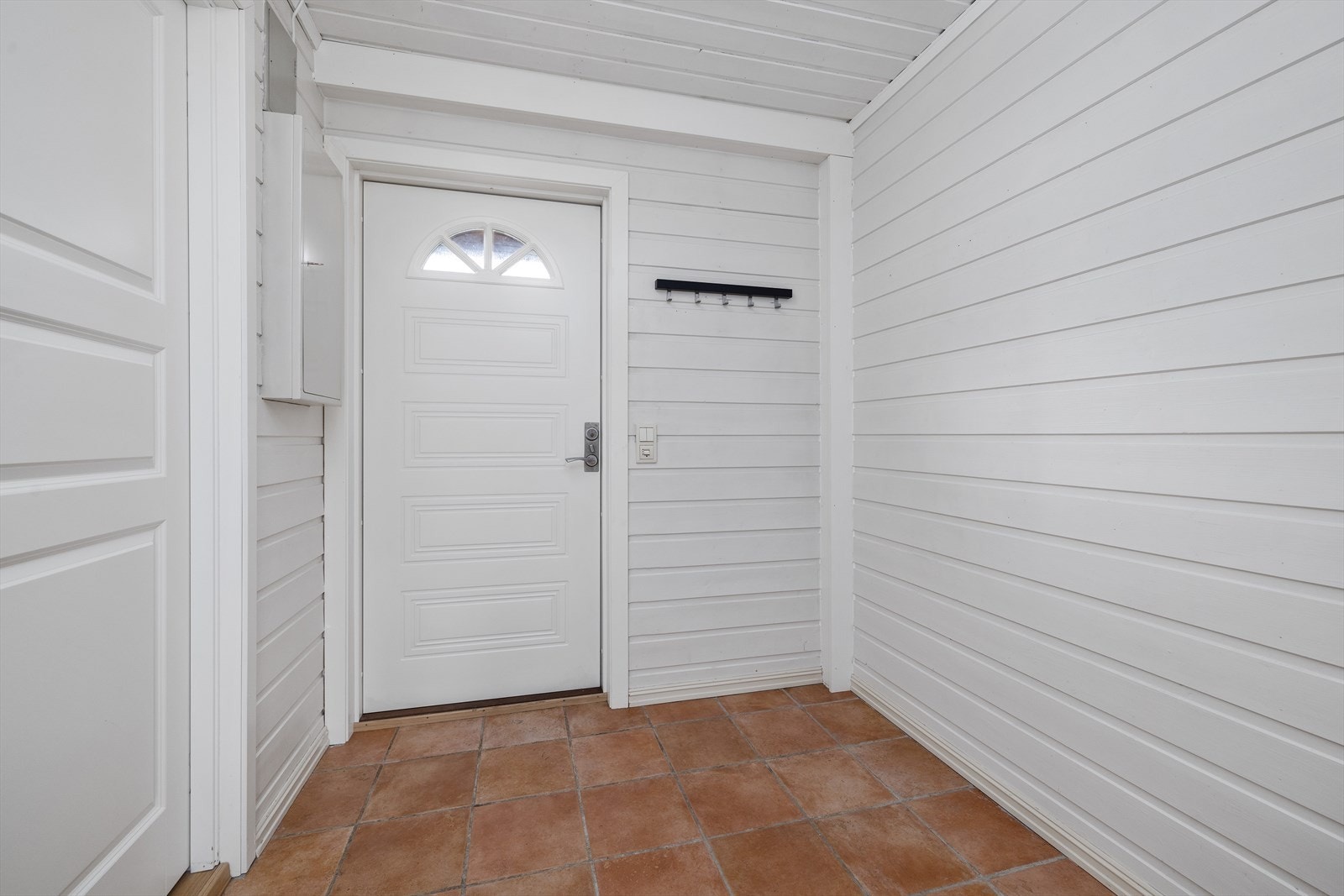 Flislagt entré med oppheng for yttertøy. Galleribilde
