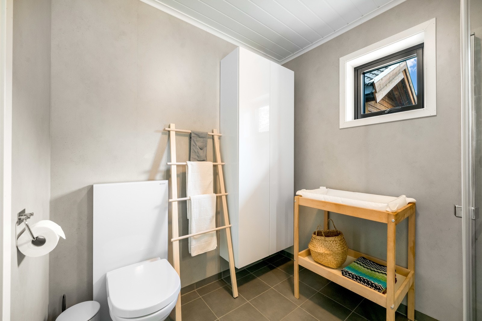 Baderommet har fliser på gulv med varmekabler. Baderomsplater på vegg og malt panel i himling. Galleribilde