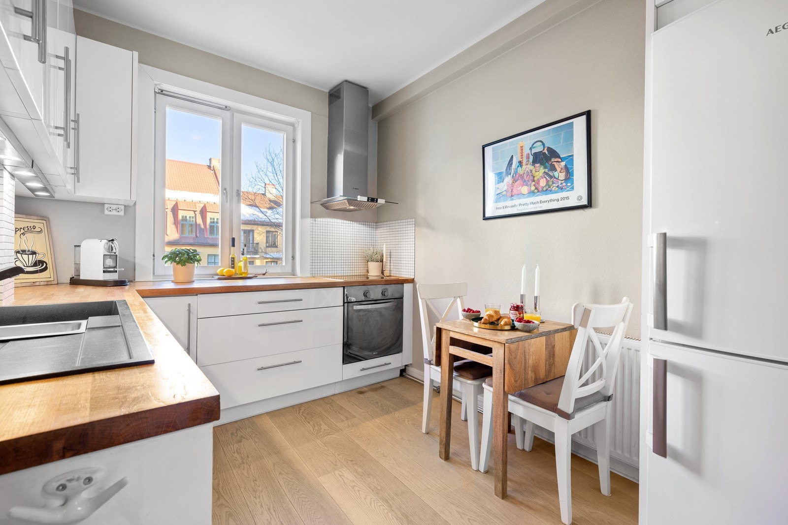 Lekkert, moderne og separat kjøkken som består av hvite fronter og benkeplate i heltre. Galleribilde