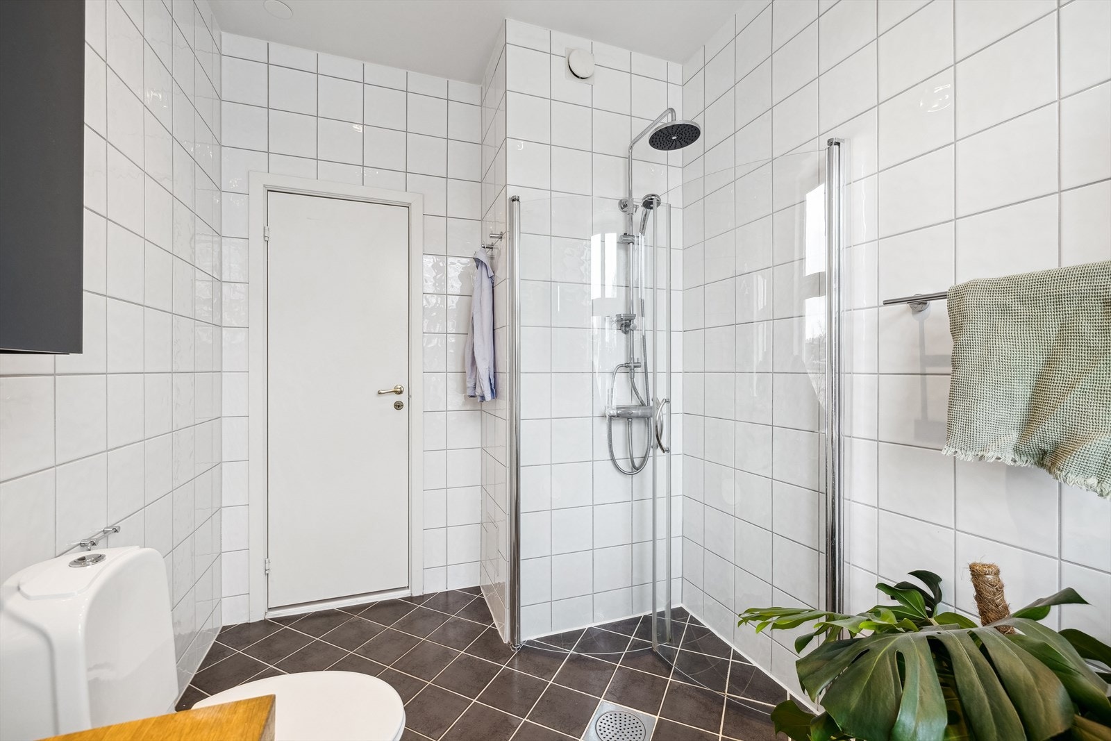 Badet er blant annet utstyrt med gulvstående klosett, dusjhjørne med innfellbare dører og servant med tilhørende skuffeinnredning. Galleribilde