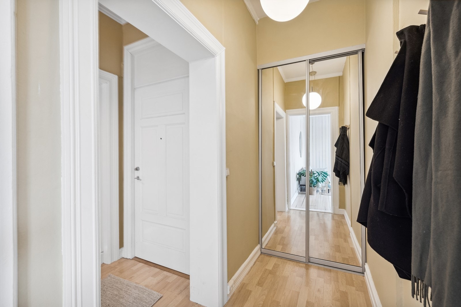 Mellomgang med ekstra lagringsplass i praktisk skyvedørsgarderobe med speilfronter. Galleribilde