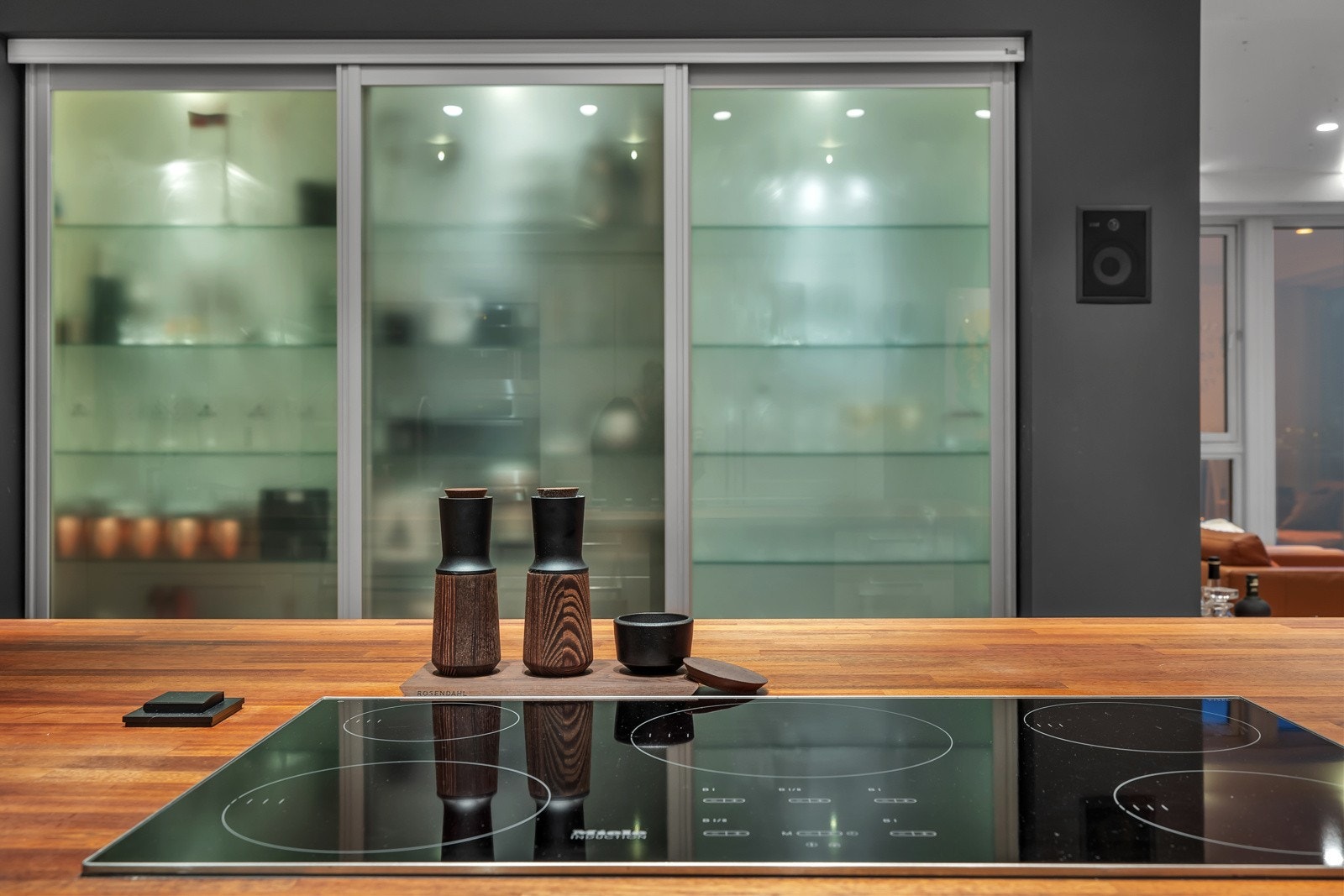 Du finner rikelig med lagringsplass i skuffer, skap og dette flotte innebygde vitrineskapet med skyvedører Galleribilde