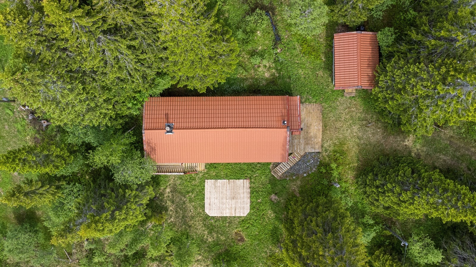 Tomten er opparbeidet med plenareal, naturtomt og terrasse på terreng. Galleribilde