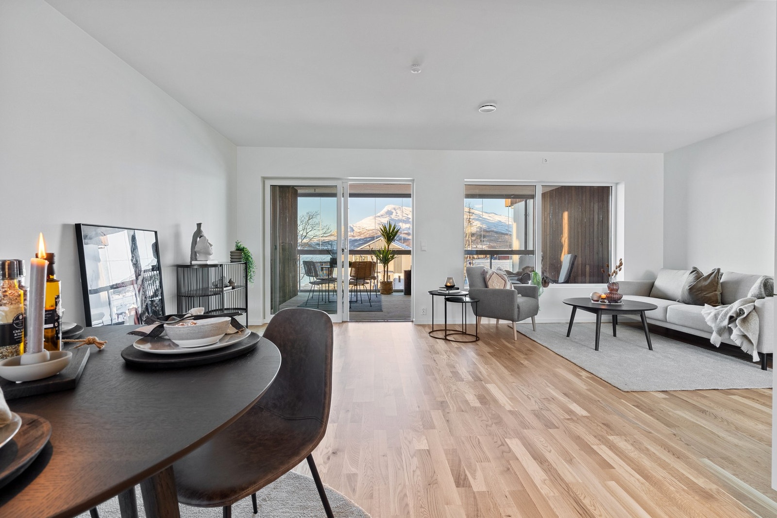 Store vindusflater i stuen gir mye naturlig lys inn i leiligheten Galleribilde