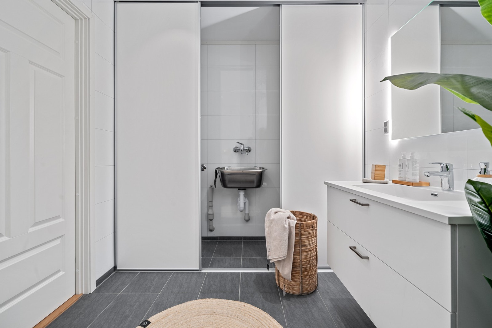 Skyvedør skjermer vaskemaskin og utslagsvask fra baderommet. Galleribilde