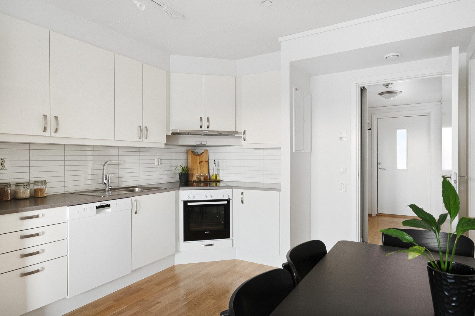 Tidløst kjøkken i hvit utførelse med hvitevarer inkludert. Galleribilde