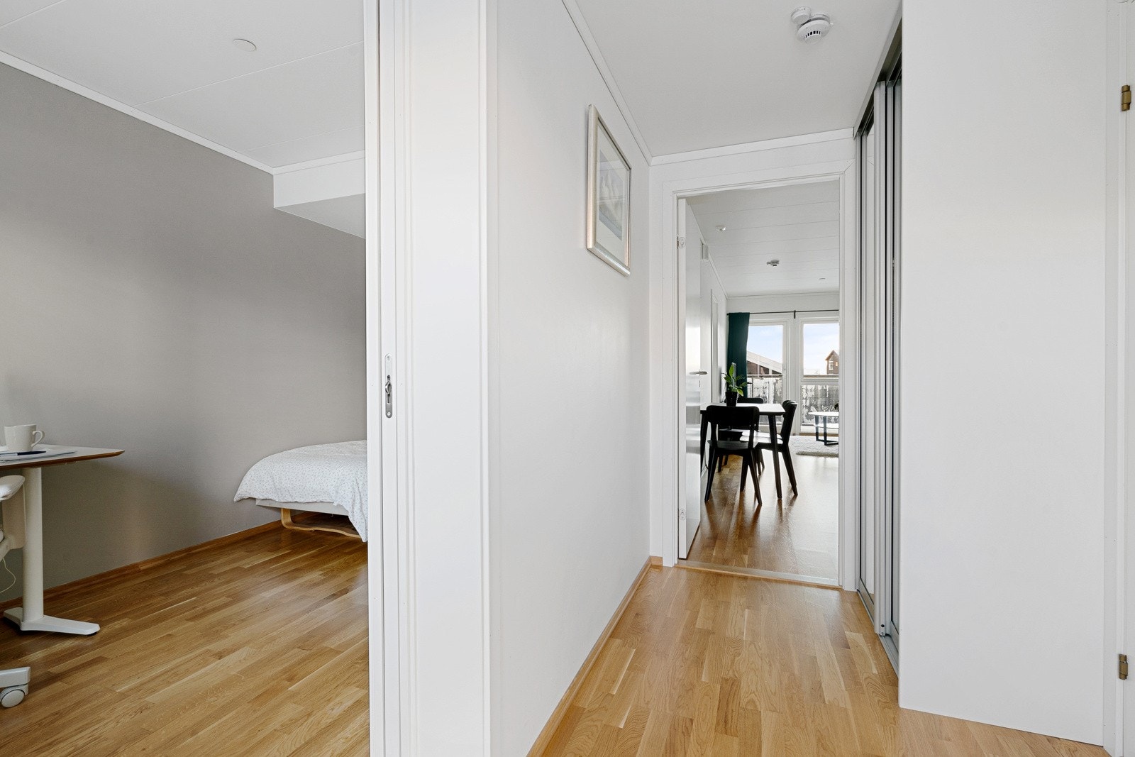 Videre tilkomst til soverom og bad. Gangen er innredet med praktisk skyvedørsgarderobe. Galleribilde