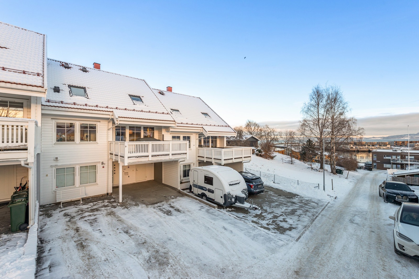 Gårdsplassen er asfaltert med steinsatt sitteplass. Carport med to ladebokser for el-bil og god plass til kjøretøy på tomten. Galleribilde