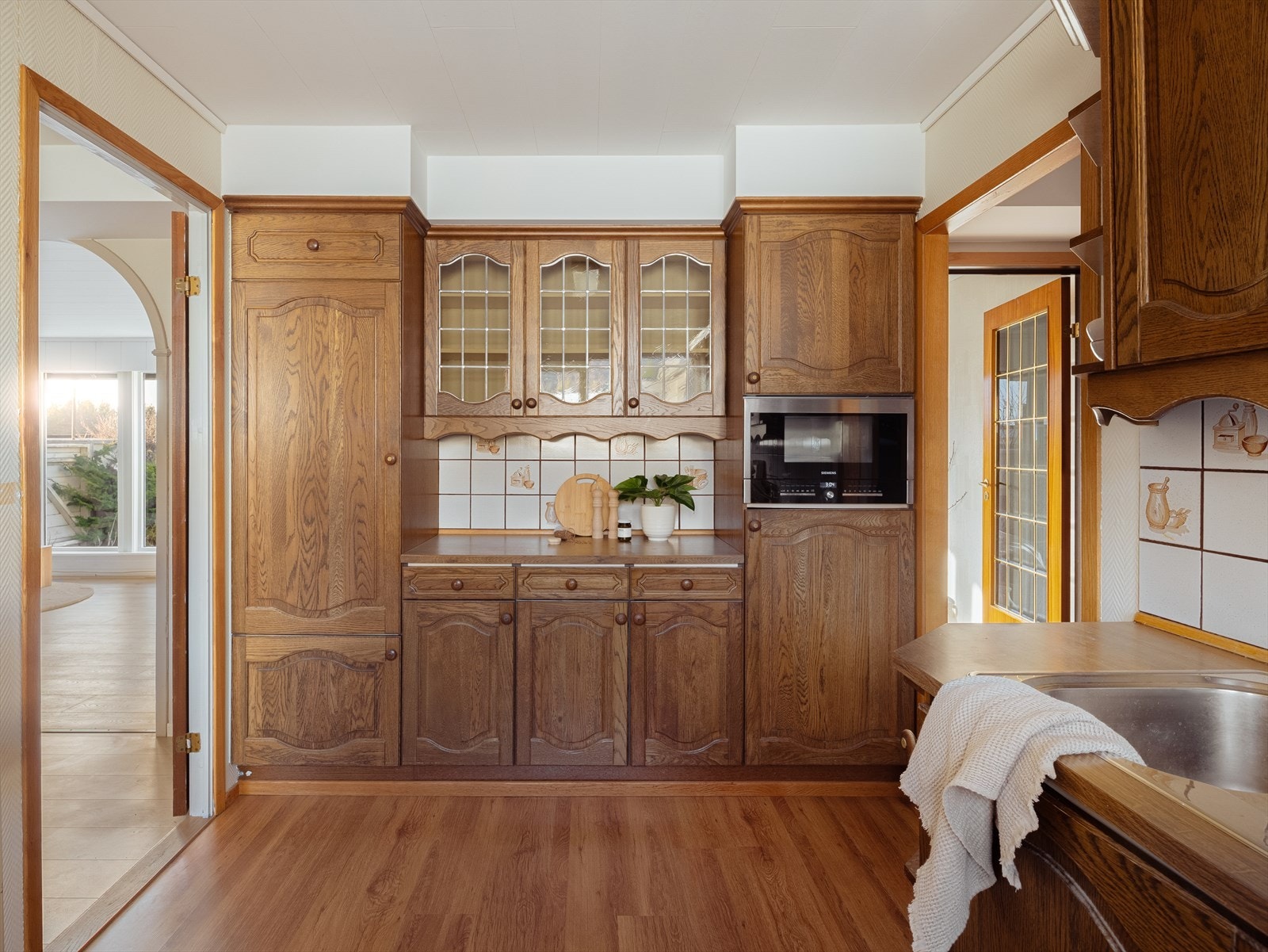 Kjøkkeninnredning av eldre opprinnelse med profilerte fronter og benkeplate av laminat. Galleribilde