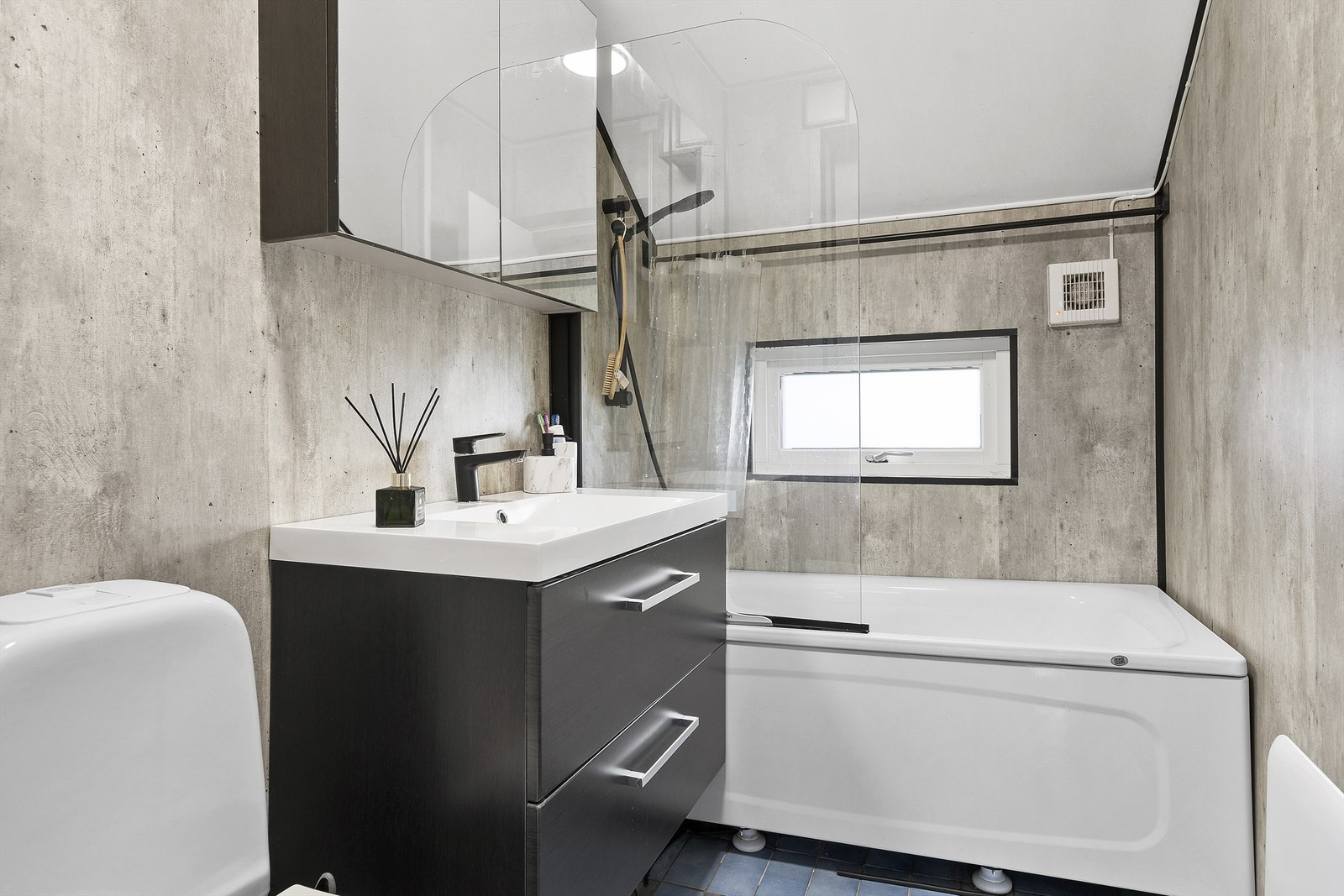 Badet har innredning med nedfelt servant, toalett og badekar Galleribilde