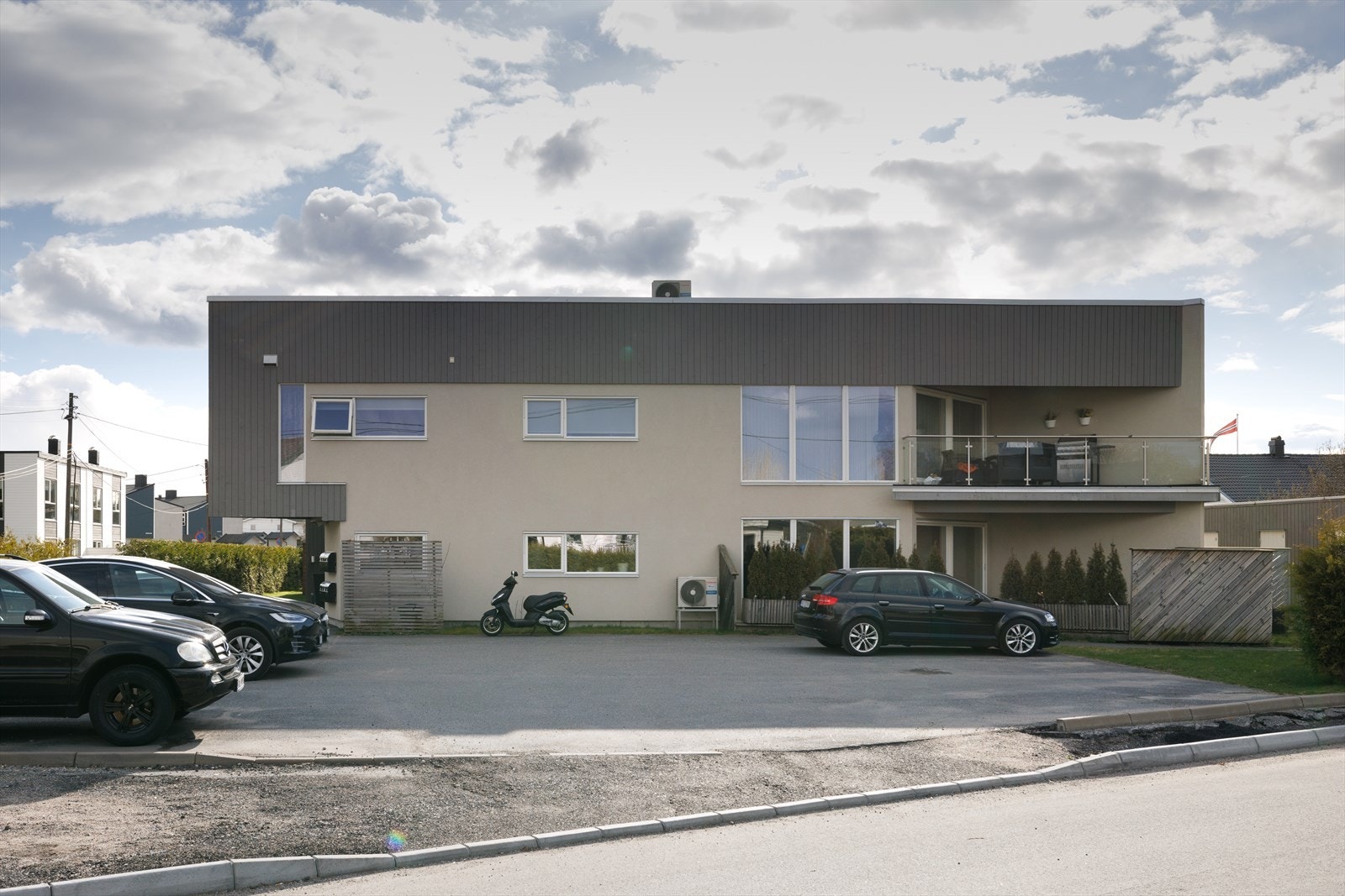 Nordsidens asfalterte parkeringsplass utgjør en stor del av fellesarealet. Galleribilde