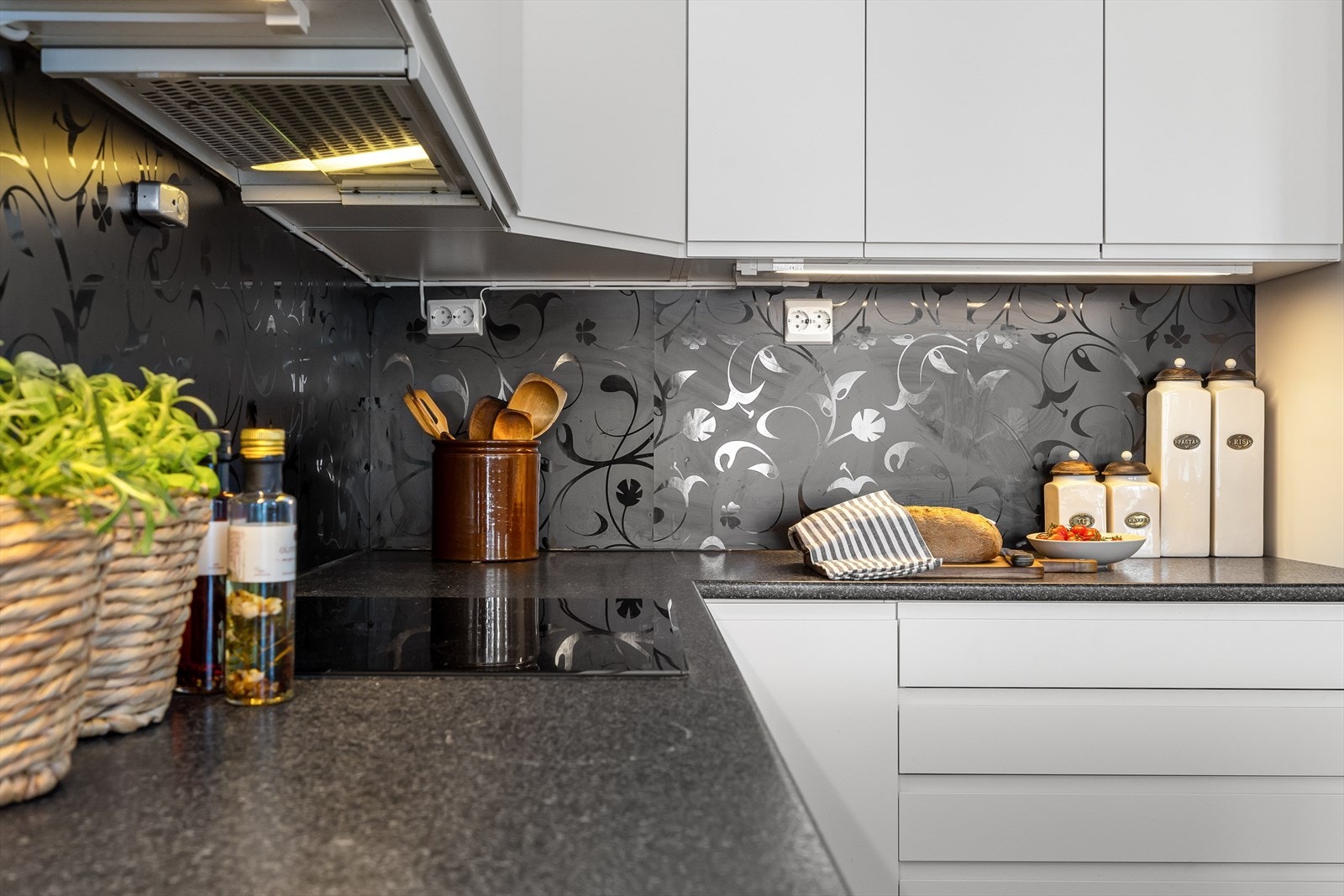 Backsplash-platen på bakveggen er også mørk med elegante blomster-ornamenter. Herfra er det enkelt å betjene spisesonen. Galleribilde