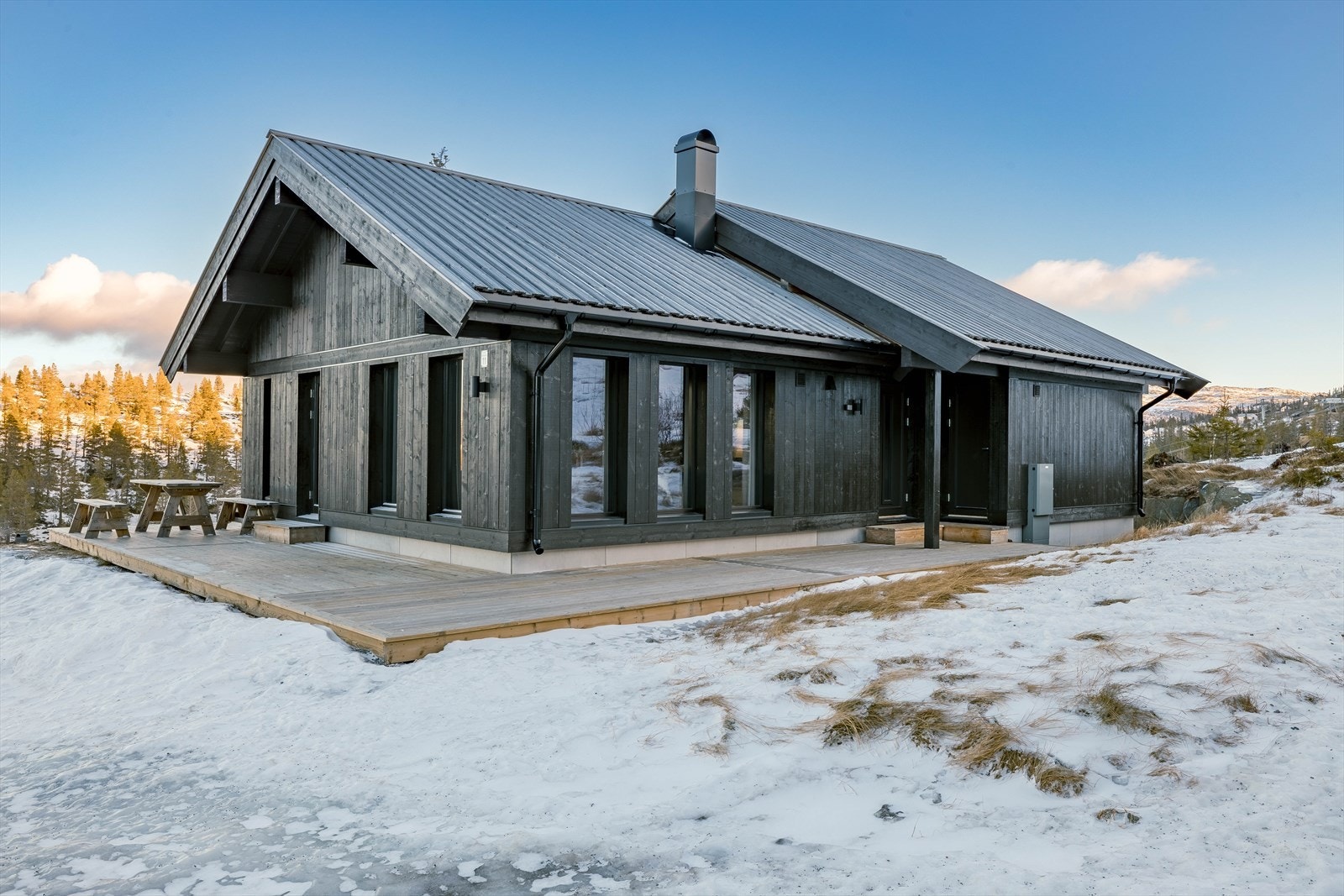 Foto fra Fyrieggvegen 19 på Hedderstun vinteren 2022 - hyttene har tilsvarende fasade og vinduer. Hytta Fyrieggvegen 19 har terrasse Galleribilde
