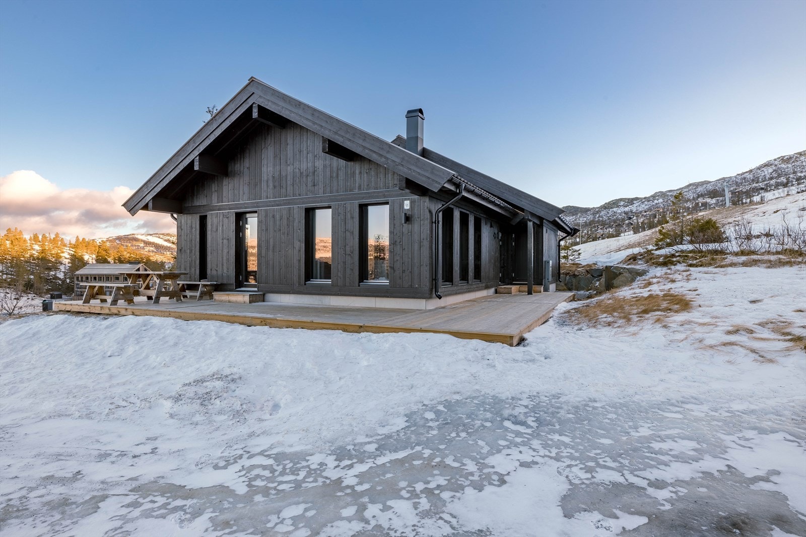 Foto fra Fyrieggvegen 19 på Hedderstun vinteren 2022 - hyttene har tilsvarende fasade og vinduer Galleribilde