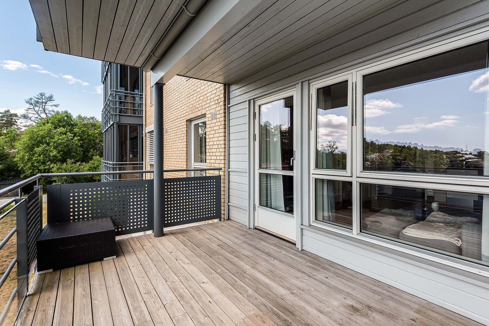 Balkongen har spaltegulv av tre og rekkverk av glass og metall. Galleribilde