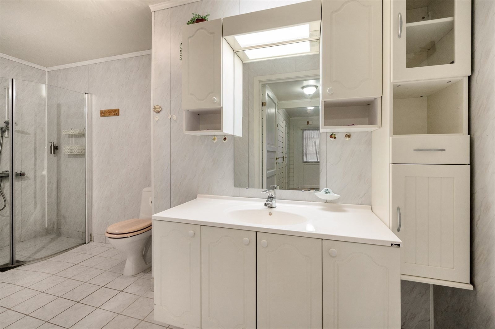 Badet har baderomsinnredning, dusjvegger og wc, samt opplegg for vaskemaskin. Galleribilde