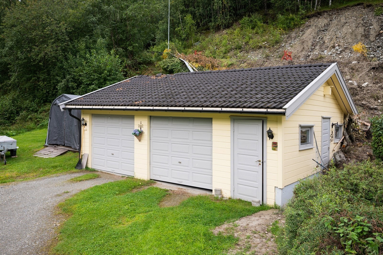 Felles garasje sammen med nabo ovenfor. Garasjen står på kommunal grunn. Garasjen er flomskadet av "Hans" og skader utbedres av forsikringsselskapet. Galleribilde