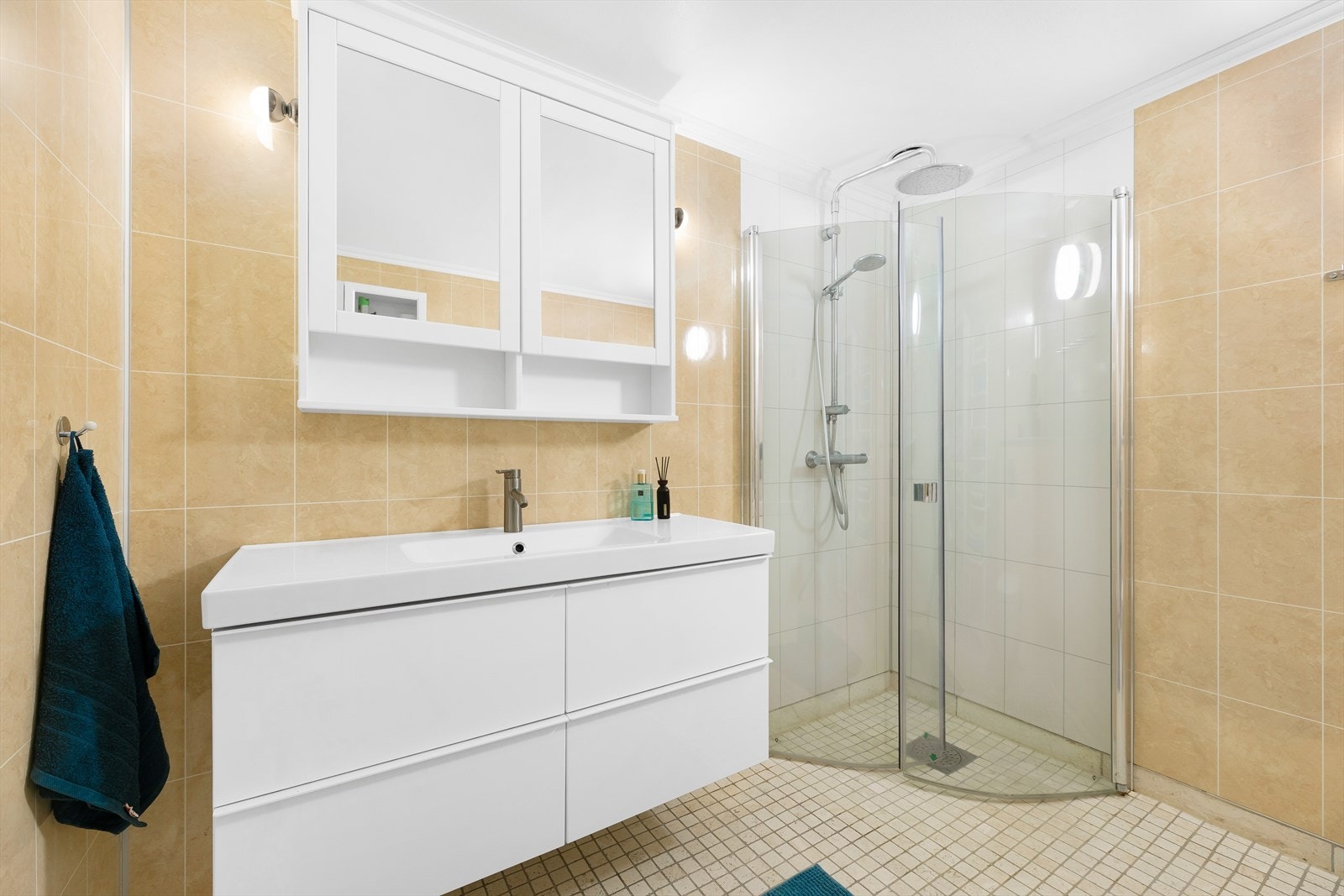 Badet har pen innredning, vegghengt toalett og et dusjhjørne med deilig regnfallsdusj. Galleribilde