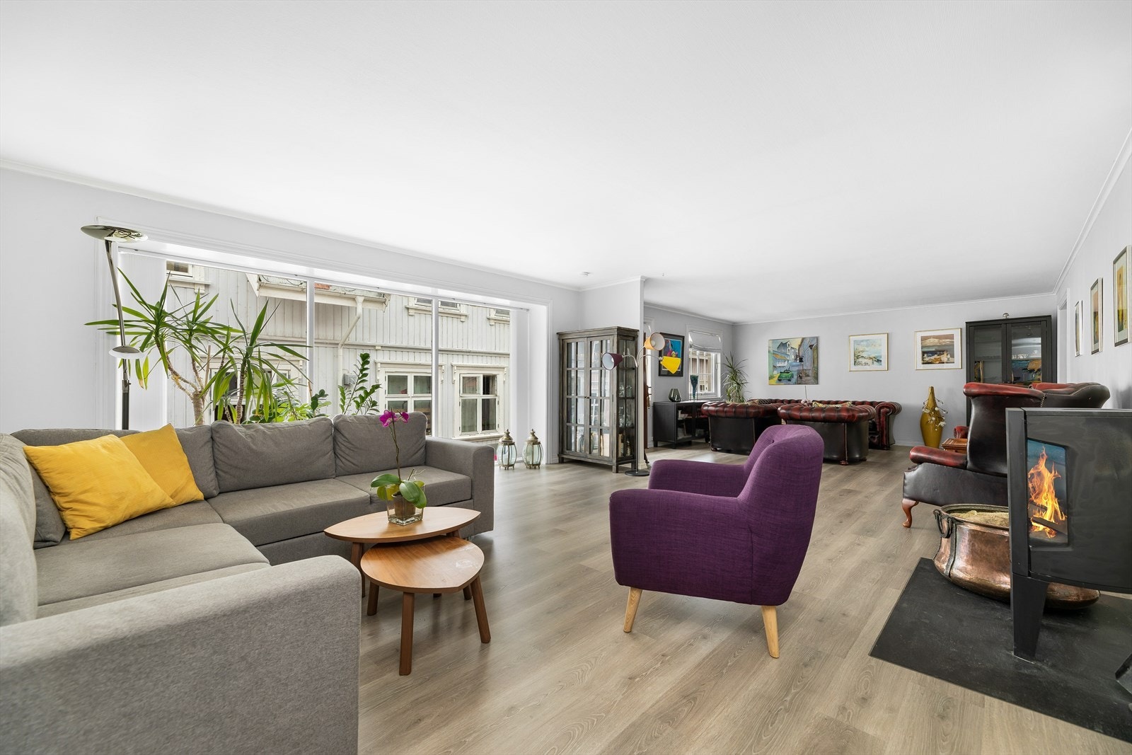 Tre store gulvvinduer fyller stuen med naturlig lys. Galleribilde