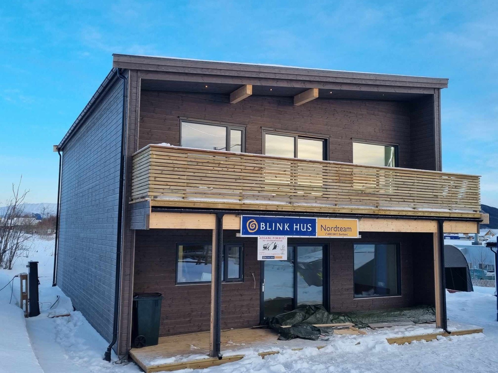 Fasade er tilnærmet ferdigstilt med platting og veranda delvis overbygd i hver etasje. Galleribilde