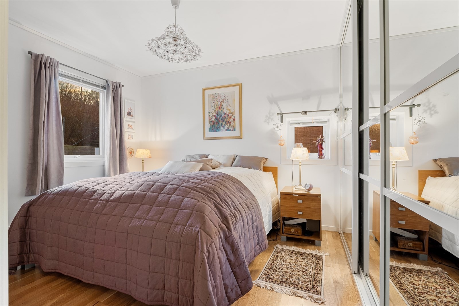 Lyst og romslig hovedsoverom med stor skyvedørsgarderobe Galleribilde