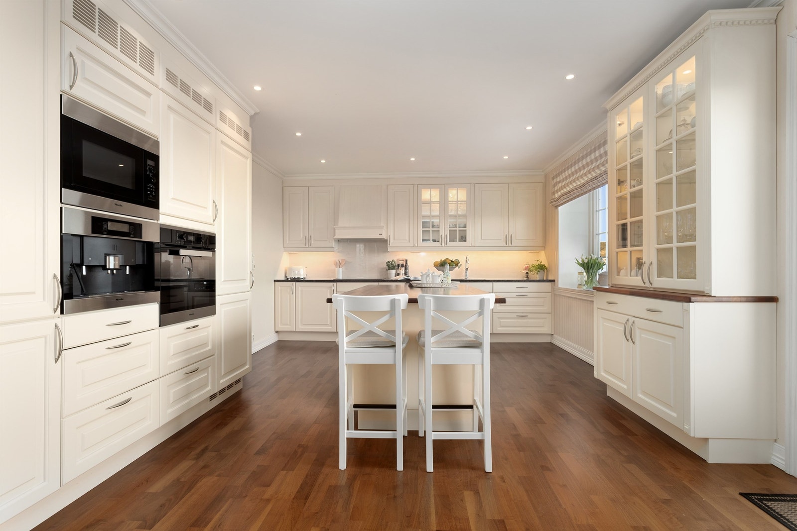 Klassisk profilert og vaniljefarget Huseby kjøkkeninnredning fra 2019 med integrerte hvitevarer Galleribilde