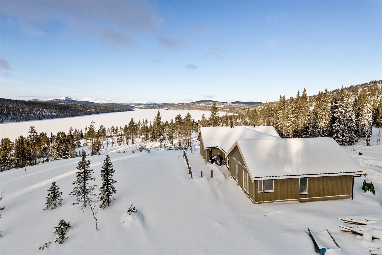 Utsikt fra toppen av tomtefeltet, og første hytta som er oppført. Galleribilde