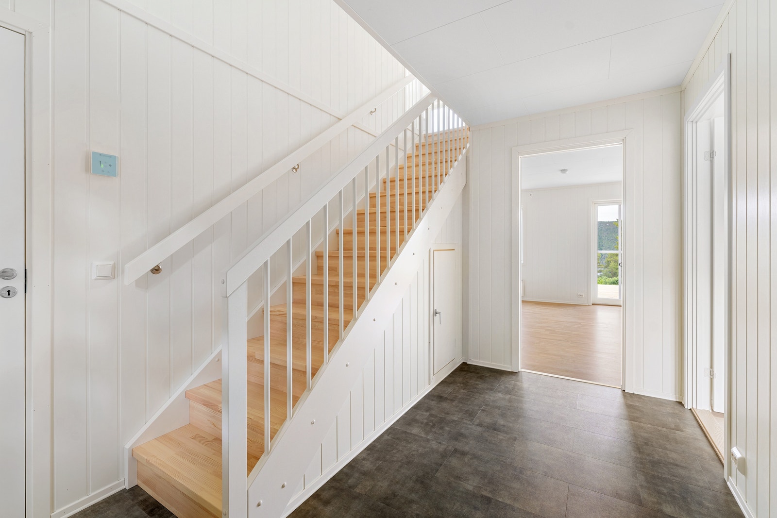 Romslig entrè med trapp til 2. etg, og liten bod under trappa Galleribilde